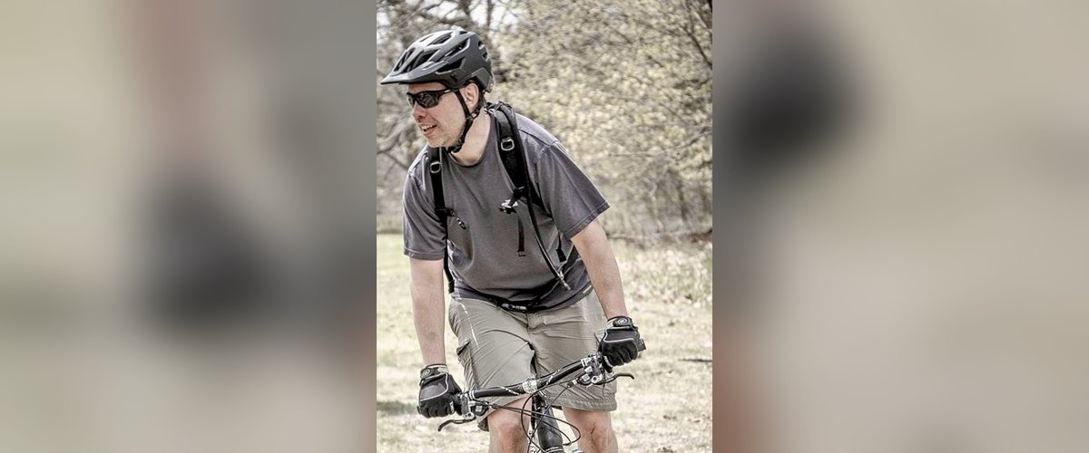 Scott riding a hardtail mountain bike through open spring woodland on the DTE Energy Foundation Trail near Ann Arbor, Michigan