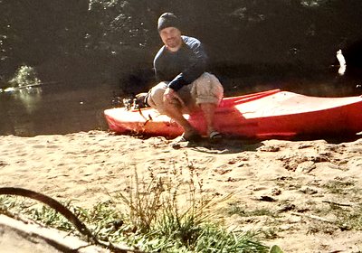 A red kayak pulled up on a sandbank beside the Big Two-Hearted River in Michigan's Upper Peninsula